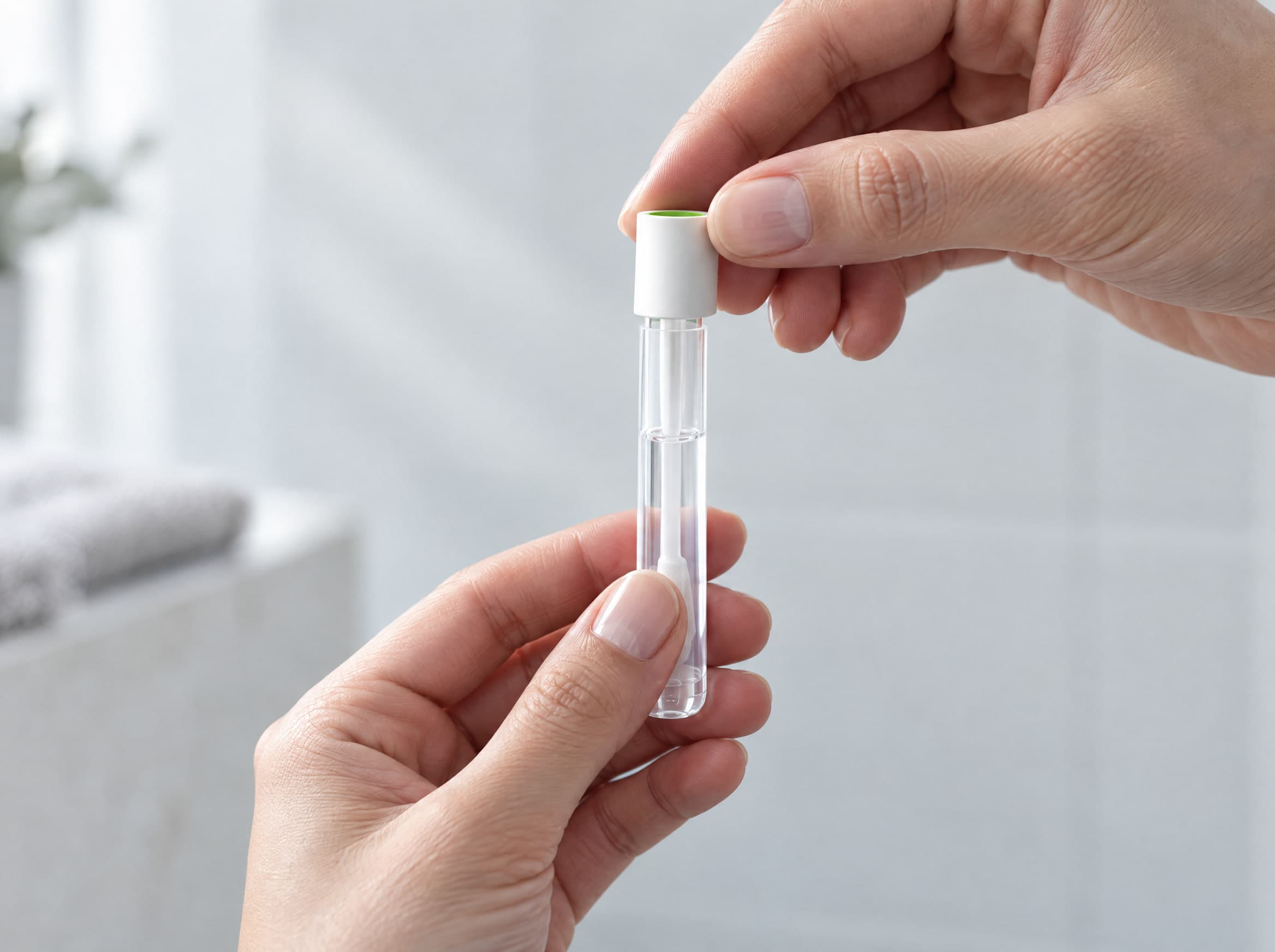 A hand capping the sample collection tube.